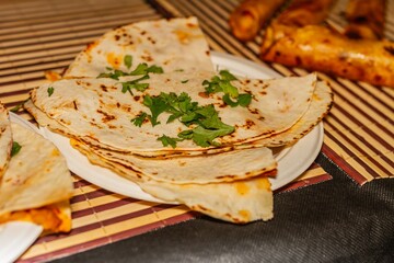 Mexican corn tortilla with cilantro on top, selective approach, gastronomy of Mexico.