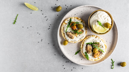 Delicious antipasti bruschetta with mussels, Crisp bread, soft cheese and arugula salad. Set of tasty appetizer sandwiches. banner, menu recipe place for text, top view