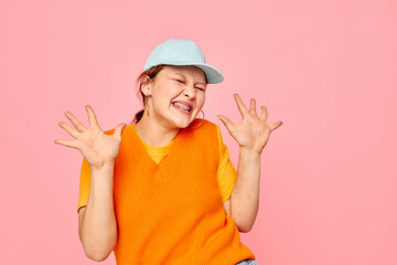 pretty girl in an orange sweater in blue caps hand gesture cropped view unaltered