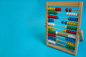 wooden children's abacus on a blue background, side view. preschool education for children. count