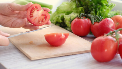woman holding fresh juicy tomatoes hands close up, vegetables and and lettuce on background
