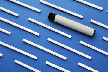 Disposable electronic smoking device and cigarettes on blue background, flat lay