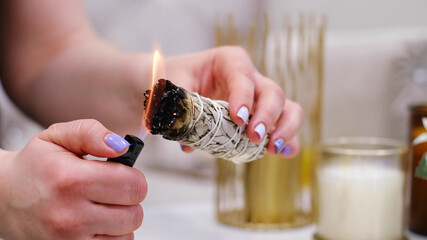 Female hand sets fire to incense on a copper bowl. Aroma therapy, to relax after a hard day. Smells for concentration, purification and clarification of consciousness.