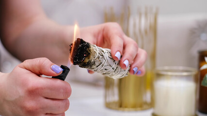 Female hand sets fire to incense on a copper bowl. Aroma therapy, to relax after a hard day. Smells...