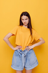 young beautiful woman fashion in yellow t-shirt denim shorts isolated background