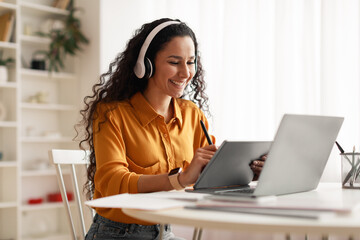 Cheerful Lady Wearing Headphones Using Tablet And Laptop In Office