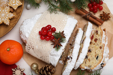 Obraz na płótnie Canvas Traditional Christmas Stollen with icing sugar on white table, flat lay
