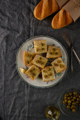 traditional baguette toasts baked with cheese, olives and olive oil. Gray background