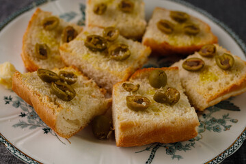traditional baguette toasts baked with cheese, olives and olive oil