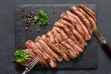 Medium meat. Grilled steak with provencal herbs on a stone board.