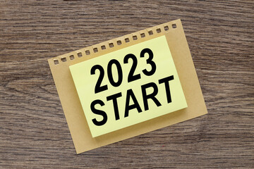 2023 START text on yellow sticker on wooden table