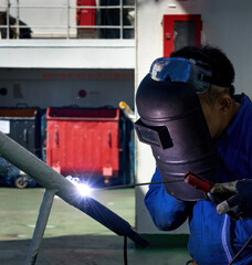 Fototapeta Welder is Welding process with sparks by MIG torch on board a ship obraz
