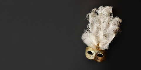 A beautiful Venetian carnival mask. Gold and white. Glow, mystery, dark background