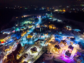 Sheregesh Kemerovo region ski resort in winter, night landscape on mountain and hotels, aerial view