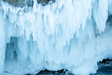 Ice cave with huge icicles on the Lake Baikal in winter. Siberia, Russia.