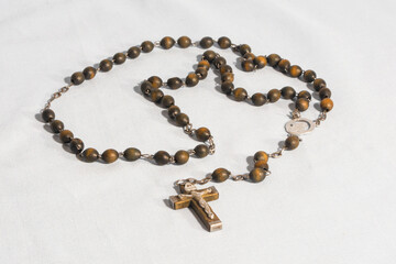 Catholic wooden rosary for prayer on a white background