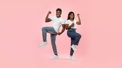 Fototapeta na wymiar Portrait of excited young black couple shaking clenched fists