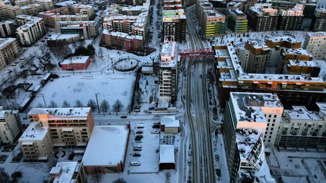 Aerial view over streets of Jatkasaari revealing downtown, winter sunset in Helsinki, Finland - tilt, drone shot
