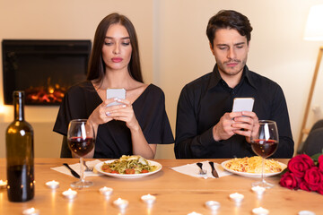 Unhappy Couple Using Mobile Phones Bored On Date