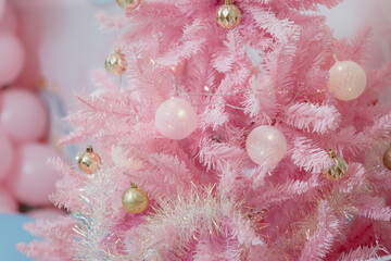 Pink Christmas tree decorated with gold and white balls. Unusual decoration for Christmas. Stylish...
