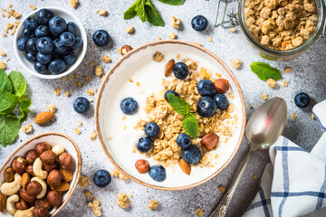 Yogurt with granola and fresh berries at stone table. Top view with copy space. Healthy food, snack or breakfast.