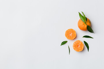 Many fresh ripe mandarin with green leaves on colored background, top view, space for text