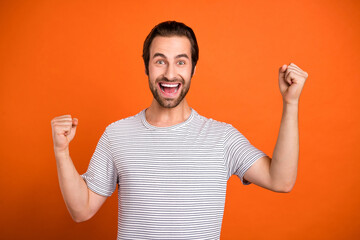 Photo of young man celebrate victory excellent triumph awesome yell isolated over orange color...
