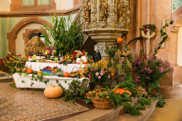 Erntedankfest in einer evangelischen Kirche - Tisch mit Früchten und Lebensmitteln unter der...