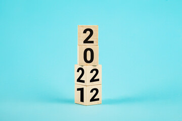 Wooden Blocks With changing number 2021 2022. New year concept. Copy space. Cube block flipping from 2021 to 2022 on a blue background, wooden cubes with the text 2022