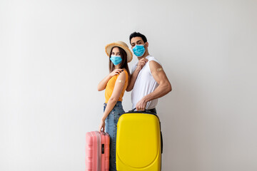 Young couple ready for safe summer holiday journey, holding suitcases and showing arms after receiving covid-19 vaccine - obrazy, fototapety, plakaty