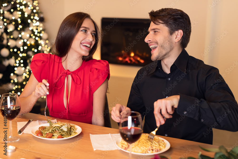 Wall mural happy woman and man eting dinner and laughing