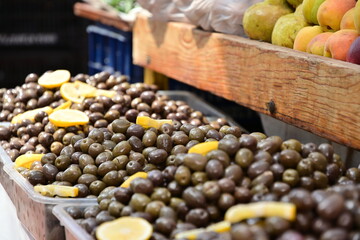 Frische, lose Oliven unverpackt mit Zitronen garniert, auf einem Markt in Tirana, Albanien