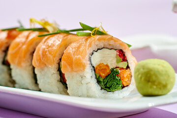 Sushi roll with salmon, cream cheese, onion and sweet potato. Bright backgrounds. Hard shadows, selective focus.