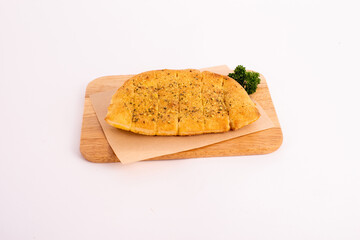 Homemade garlic bread on the wooden plate.