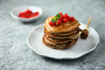 Homemade pancakes with berries and honey