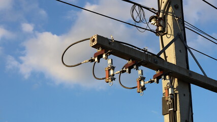 Drop fuse cutout high voltage on the pole. Set of cutout fuses to maintain devices for protection against overloads or short circuits on a blue sky background with copy space. Selective focus