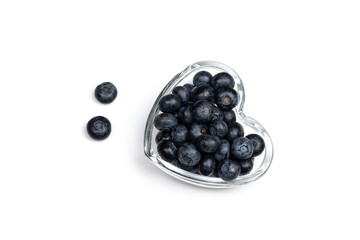 Ripe fresh blueberry in heart shaped plate on white background.