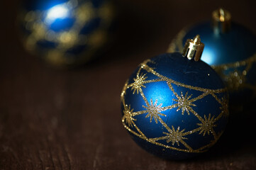 Blue Christmas tree toys on a dark background lie on a dark table