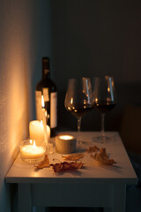 Candlelight date - two glasses of red wine and bottle of wine with candles on the table