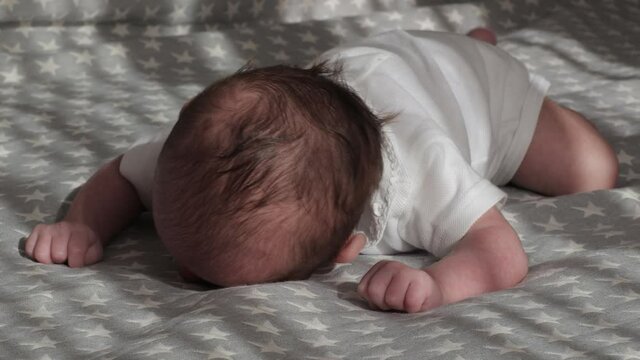 Little newborn baby lying on his stomach having tummy time.