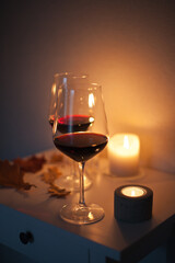 Candlelight date - two glasses of red wine with candles on the table. Romantic night with wine