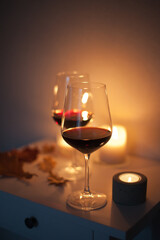 Candlelight date - two glasses of red wine with candles on the table. Romantic night with wine