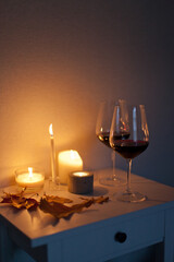 Candlelight date - two glasses of red wine with candles on the table. Romantic night with wine