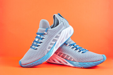 Stability and cushion running shoes. New unbranded running sneaker or trainer on orange background....