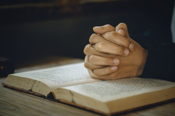 Christian life crisis prayer to god. Women Pray for god blessing to wishing have a better life. Hands praying to god with the bible. believe in goodness. Holding hands in prayer on a wooden table.