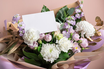 modern bouquet of different flowers, golden leaves and blank paper card on color background. Valentines day, birthday stationery mockup scene
