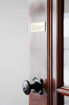 Open wooden door with sign: push in german language