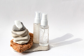 Obraz na płótnie Canvas Tower from multi-colored stones with a transparent bottle bubble gel on a white background. Natural podium with cosmetics