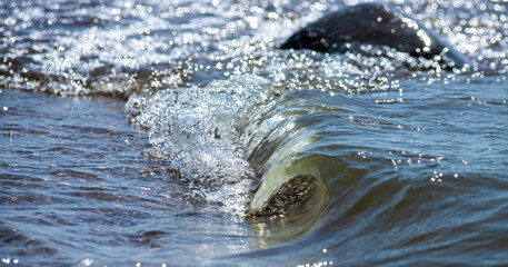 Close-up of sea foam on the sand beach with summer sunlight