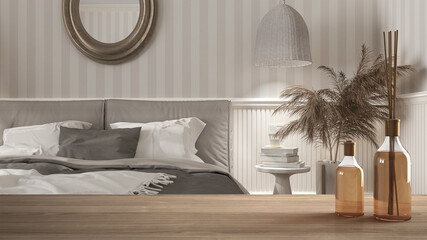 Wooden table top or shelf with aromatic sticks bottles over sustainable white classic bedroom with double bed, striped wallpaper and woodwork, architecture interior design